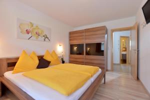 a bedroom with a large bed with yellow sheets at Appartement Angelika in Schwendau