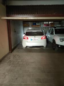 two cars are parked in a parking garage at white house in Bari