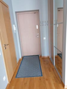 una stanza con una porta con un tappeto sul pavimento di Saulės Sonata Etude a Druskininkai