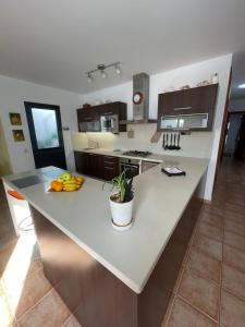 kuchnia z dużą białą wyspą z owocami w obiekcie apartamento anzuelo w mieście Famara
