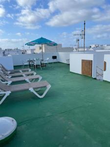 patio z krzesłami i parasolem na dachu w obiekcie apartamento anzuelo w mieście Famara