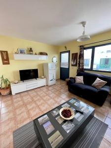 salon z kanapą i stołem w obiekcie apartamento anzuelo w mieście Famara