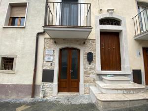 ein Gebäude mit einer Holztür und einem Balkon in der Unterkunft B&B Il Giardino Nascosto in Roseto Valfortore