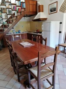 a kitchen with a wooden table with chairs and a staircase at La Piazzetta in Bettona