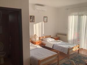 a bedroom with two beds and a window at Sobe Pipić in Široki Brijeg
