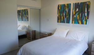 a bedroom with a white bed and a mirror at Diamante 181 Luxury home in Gold Coast 4 Bedrooms 3 Bath in Palm-Eagle Beach +33 photos