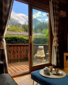 a room with a large window with a view of a mountain at Family Chalet Central Chamonix Mont Blanc Views in Chamonix-Mont-Blanc
