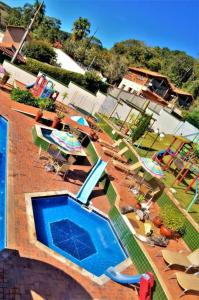 an outdoor swimming pool with lawn chairs and umbrellas at Summit Lago Hotel in Lambari