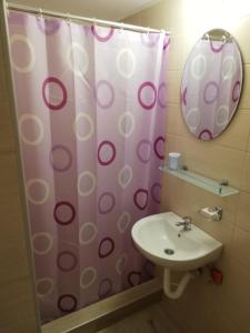a bathroom with a shower curtain and a sink at Sobe i apartmani Simic in Ribarska Banja