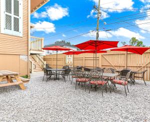Un patio con mesas y sillas y sombrillas rojas. en Nitey Nite Inn, en Nueva Orleans