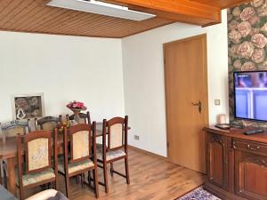 ein Esszimmer mit einem Tisch und einem TV in der Unterkunft Ferienhaus zwischen Bach und Luther mit Sauna & Garten in Eisenach