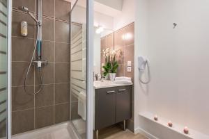 瓦訥的住宿－瓦納舒適城市公寓酒店，带淋浴和盥洗盆的浴室