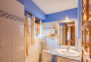 a bathroom with a sink and a toilet and a mirror at Casa Manadero in Robledillo de Gata