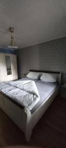 Una cama con sábanas blancas y almohadas en un dormitorio en FeWo Am Marktplatz en Zerf