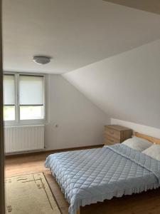 1 dormitorio blanco con 1 cama y 2 ventanas en Bükkfői vendégház, en Borzont