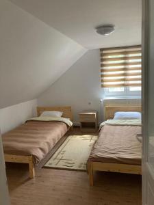 1 dormitorio con 2 camas y ventana en Bükkfői vendégház, en Borzont