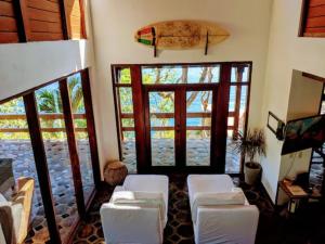 a living room with white chairs and a surfboard on the wall at Shankton Tower in El Gigante