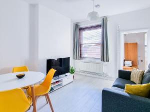 a living room with a table and a couch and a tv at Pass The Keys Beautiful 2 Bedroom Apartment in Wimbledon in London