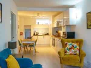 a kitchen and living room with a couch and a table at Pass The Keys Modern 2 bed flat overlooking Aberaeron Harbour in Aberaeron