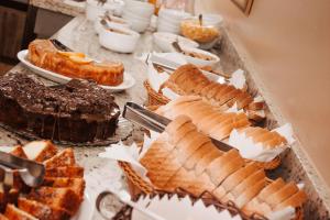 a table topped with different types of cakes and pastries at Hotel Colina São Francisco in Gramado