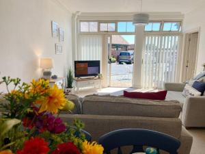 a living room with a couch and a tv at Coastal Mews House close to Beach in Felixstowe