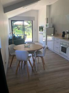 eine Küche und ein Esszimmer mit Tisch und Stühlen in der Unterkunft Gîte des Allas in Campagne
