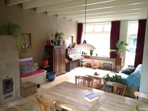 een woonkamer met een tafel en een woonkamer met een bank bij Logies de Zeeuwse Klei, een gezellig jaren 30 huis in Middelburg