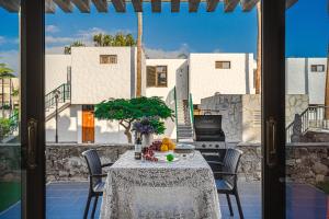 a table with a vase of fruit on top of a balcony at BUNGALOW -2 minute from the beach. in Playa de las Americas