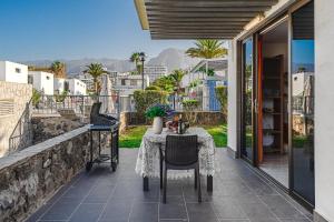 a patio with a table and chairs on a balcony at BUNGALOW -2 minute from the beach. in Playa de las Americas