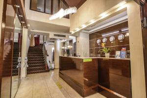 a lobby with a bar and a staircase with clocks at Aegeon Hotel in Thessaloniki