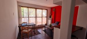 uma sala de estar com uma mesa e uma parede vermelha em Loft a metros Peatonal sarmiento em Mendoza