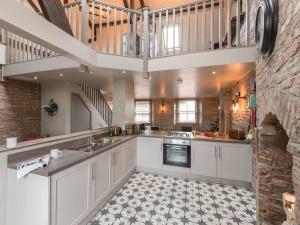 a large kitchen with white cabinets and a staircase at Newgate Loft in Morpeth