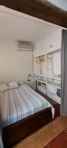 um quarto com uma cama num quarto branco em Loft a metros Peatonal sarmiento em Mendoza