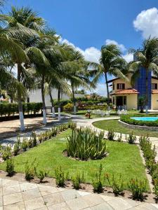 a resort with palm trees and a swimming pool at Condomínio Portal do Paraíso in Lucena