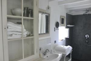 een witte badkamer met een wastafel en een spiegel bij Mas de Rique in Saint-Étienne-du-Grès +43 foto's