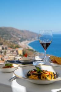 stół z talerzami żywności i kieliszkiem wina w obiekcie Splendid Hotel Taormina w Taominie