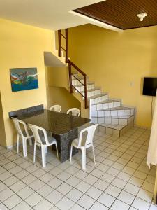a dining room with a table and chairs and stairs at Condomínio Portal do Paraíso in Lucena