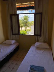 two beds in a room with a window at Condomínio Portal do Paraíso in Lucena +33 photos