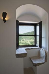 a window in a white room with a seat and a view at Eremito in Parrano