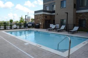 マーフリーズボロにあるStaybridge Suites Nashville SE - Murfreesboro, an IHG Hotelの大きなスイミングプール(椅子付)と建物