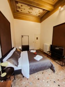 1 dormitorio con 1 cama grande y TV en Residenza Studio delle Arti en Bolonia
