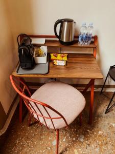 einen Schreibtisch mit einem Stuhl neben einem Tisch mit Wasserflaschen in der Unterkunft Residenza Studio delle Arti in Bologna