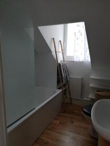 a bathroom with a bath tub and a window at La Plage in Fécamp