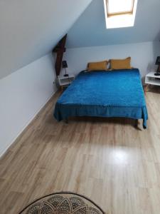 a bedroom with a bed and a wooden floor at La Plage in Fécamp