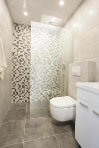 uma casa de banho branca com um WC e um chuveiro em apartman Fuerte 1 em Belgrado