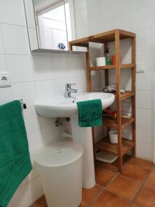 Un baño con lavabo, inodoro y espejo. en Balancon pool, en El Médano
