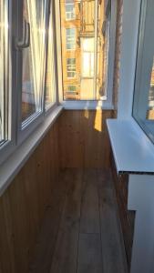 um quarto vazio com duas janelas e um piso de madeira em 2-х кімнатна квартира студія у центрі Миргорода em Myrhorod