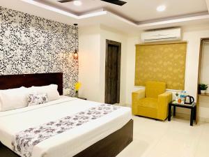a bedroom with a bed and a yellow chair at Hotel oak by signature airport zone hyderabad in Shamshabad +27 photos