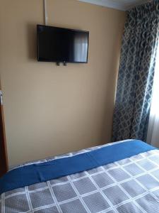 a bedroom with a bed with a flat screen tv on the wall at TM Self Catering Accommodation in Middelburg