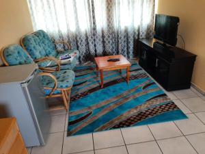 a living room with two chairs and a tv at TM Self Catering Accommodation in Middelburg
